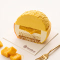 Cut Golden Mango mousse cake revealing the interior mousse layers and fruit filling