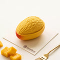 Finished Golden Mango mousse cake with textured fruit flesh and a realistic half mango base