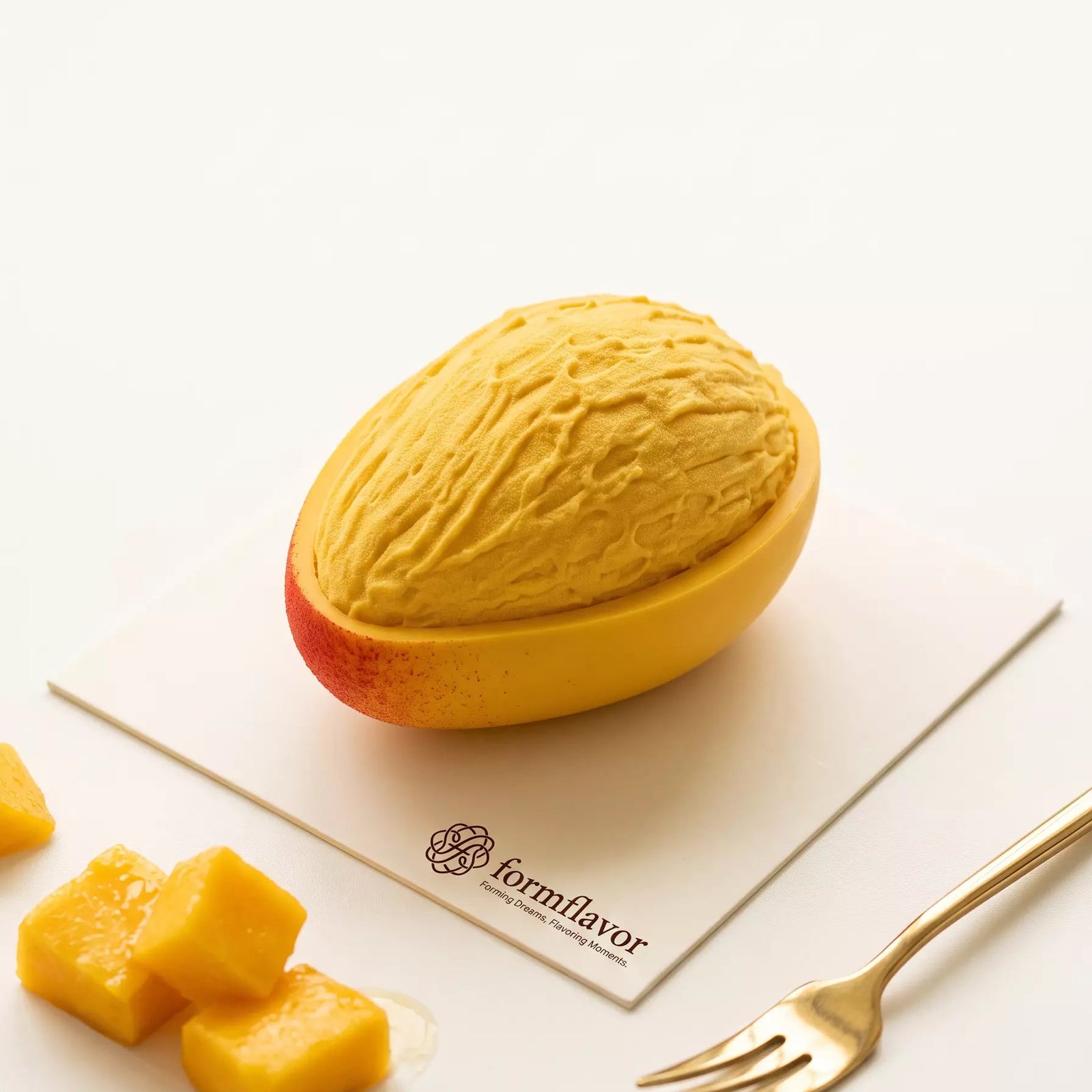 Finished Golden Mango mousse cake with textured fruit flesh and a realistic half mango base