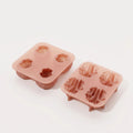 Angled view of pink walnut shell and kernel silicone molds, with textured cavities facing upward.