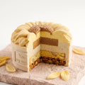 Cross section of a sunflower mousse cake showing the mousse layers, filling, sponge, and crunchy base.
