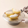 Velvet spray finishing process on the Sunny Banana realistic banana-shaped mousse cake